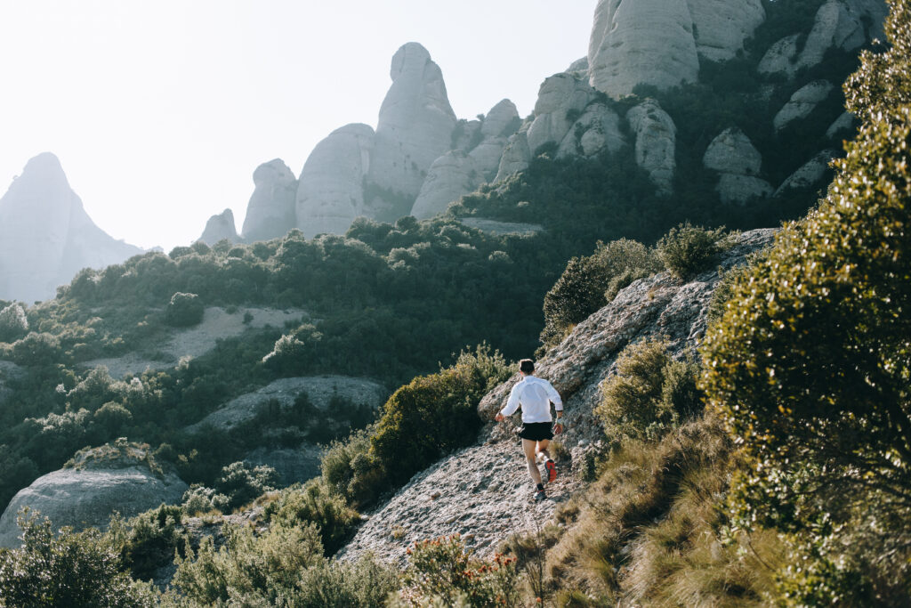 allenamento ibrido: trail runner che corre tra le montagne